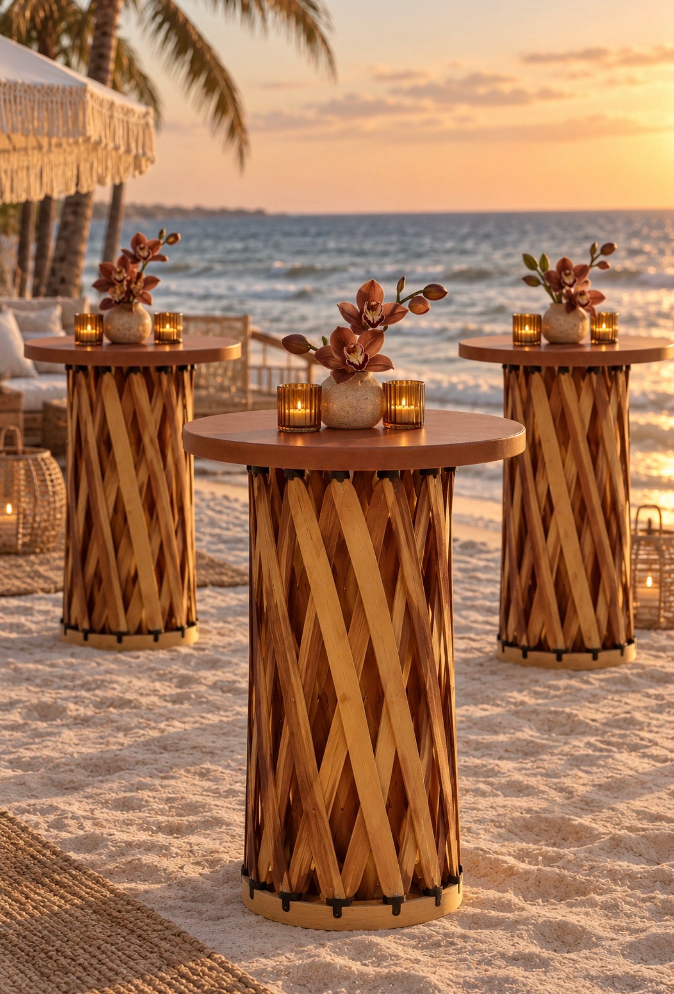 Three handcrafted woven wood cocktail tables with leather tops styled with orange floral arrangements and candles at an outdoor Florida garden wedding.