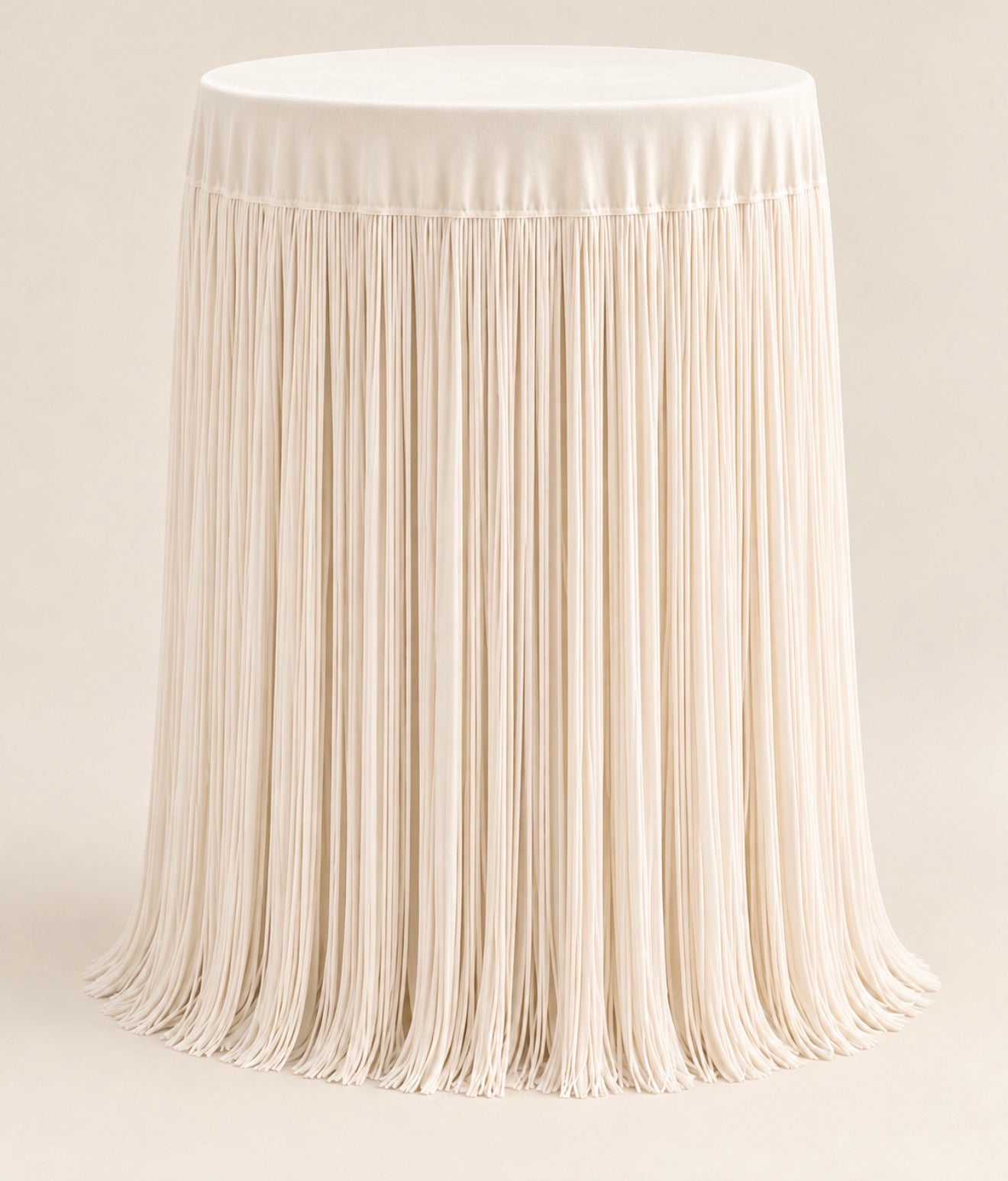 White handmade fringe cocktail tablecloth with flowing floor-length fringe and a smooth fabric top, displayed on a round cocktail table.